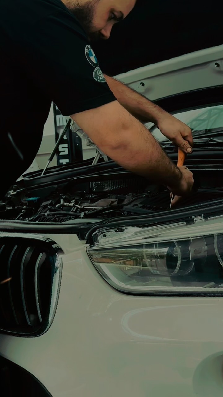 Mecânico especializado realizando manutenção em BMW branca